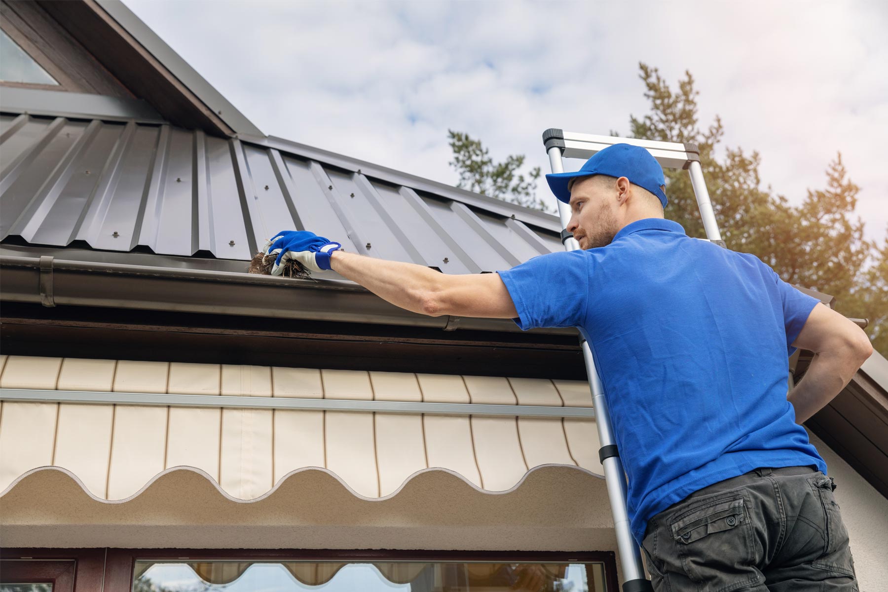 https://handymanconnection.com/wp-content/uploads/2025/04/homeguide-handyman-cleaning-gutters-on-residential-house-1.jpg