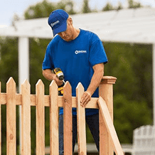 fence handyman installing new wooden fence posts